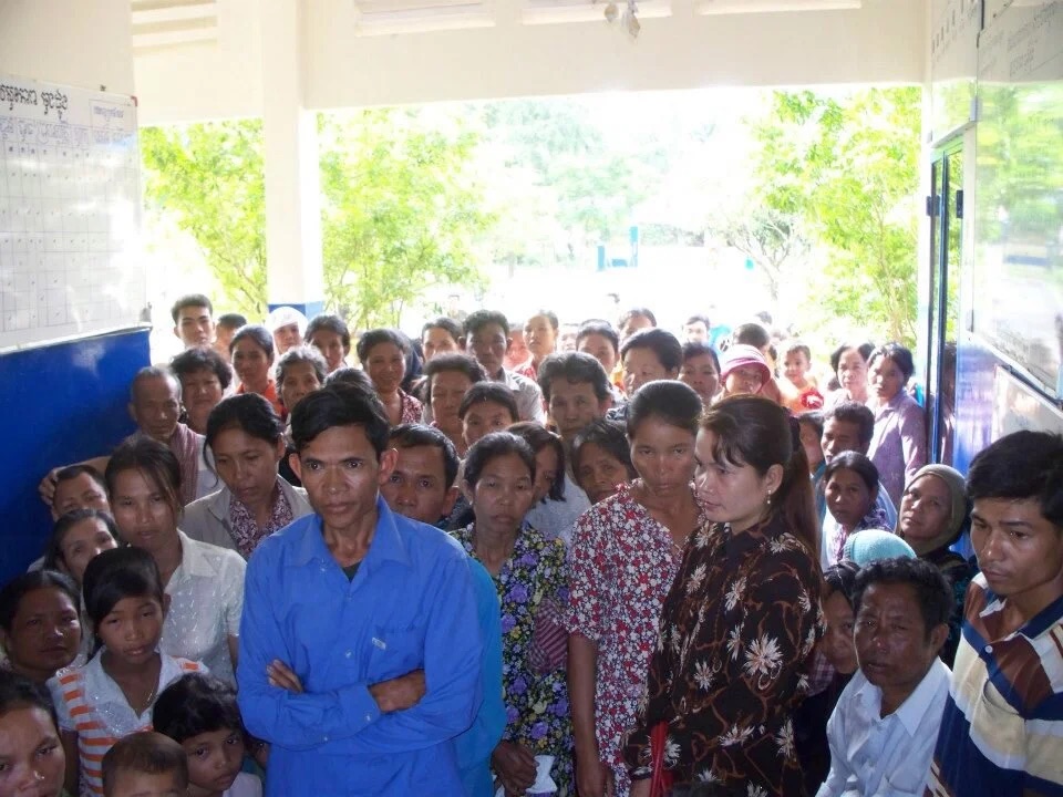A young mother holding her baby on a bench at the clinic.