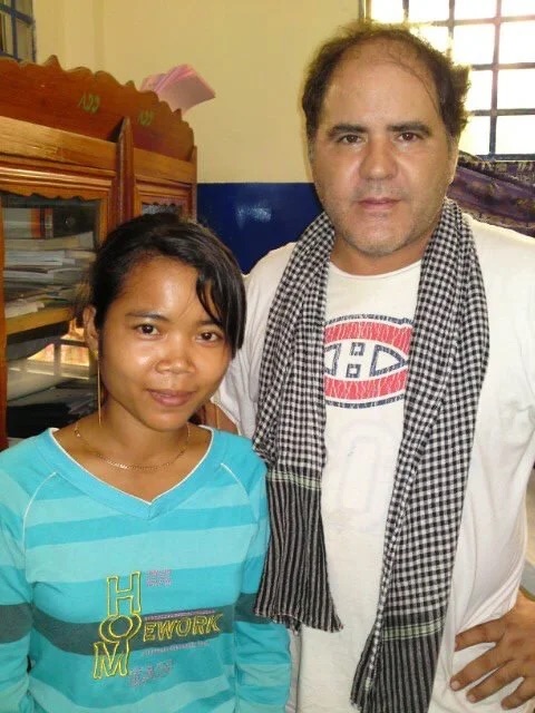 James Garcia holding a newborn wrapped in a blanket outside the clinic.