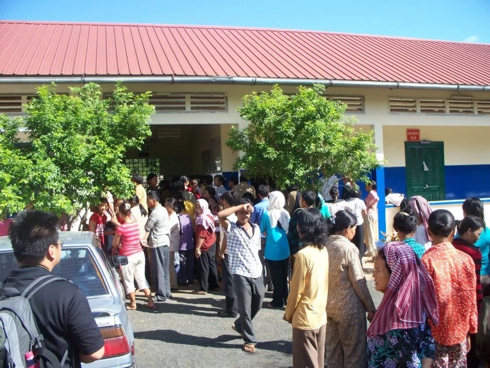Clinic staff in masks working with medical equipment and oxygen cylinders.