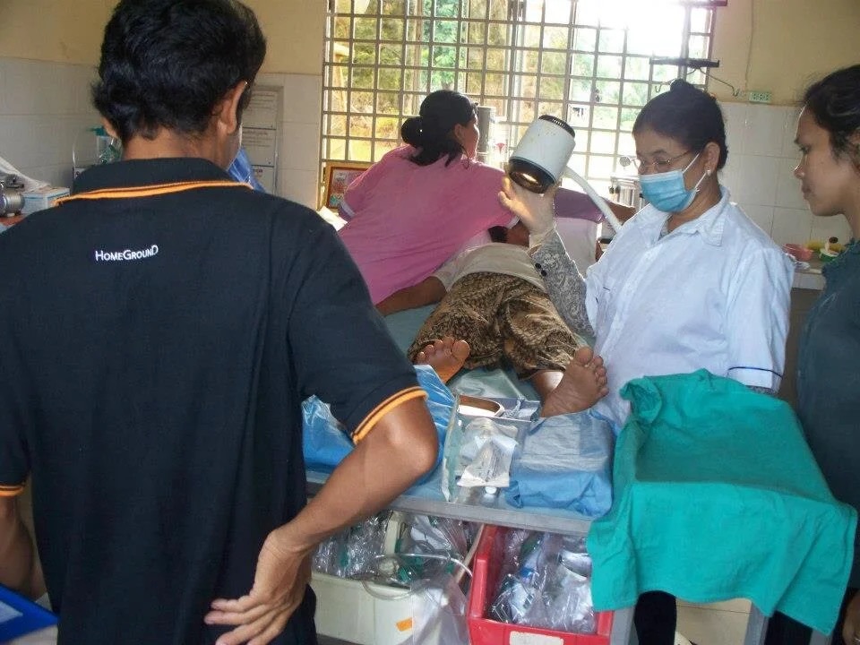 The exterior of the Chong Dong clinic building with villagers gathered outside.
